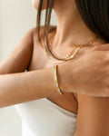 Gold crystal bangle bracelet on model wrist, elegant minimalist jewelry style