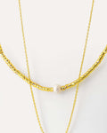 Layered necklace with natural pearl and geometric pendant, crafted from 18K gold-plated brass on neutral background
