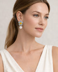 Model wearing Jadejuri blue flower pearl drop earrings, elegant close-up portrait