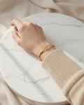 18K gold-plated bamboo cuff bracelet on model hand, minimalist jewelry