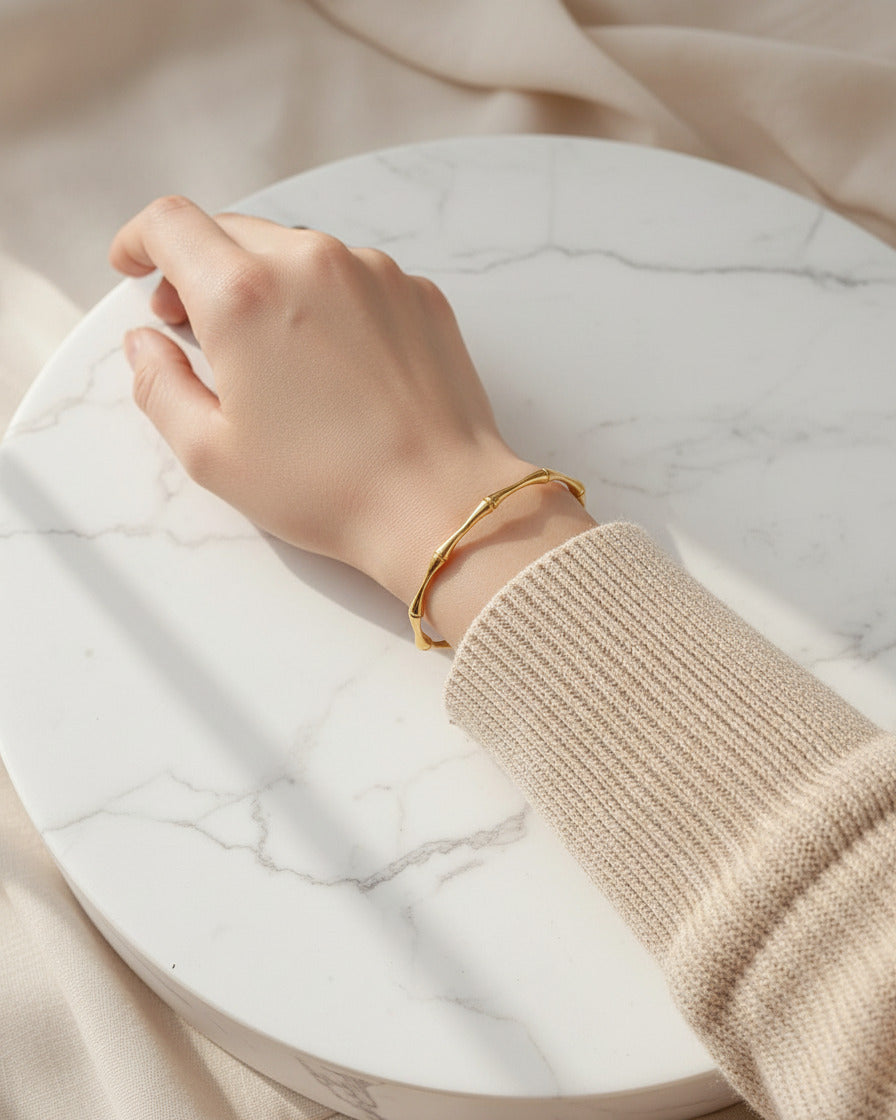 18K gold-plated bamboo cuff bracelet on model hand, minimalist jewelry