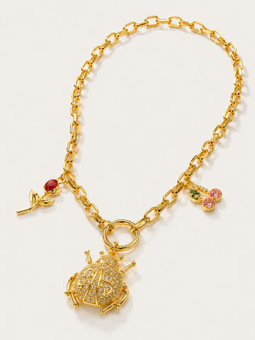 Gold bracelet with charms on a white background