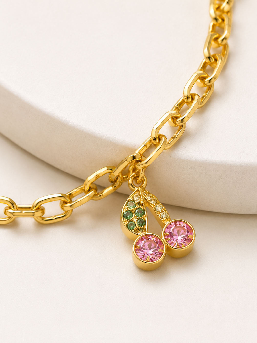 Gold bracelet with charms on a white background