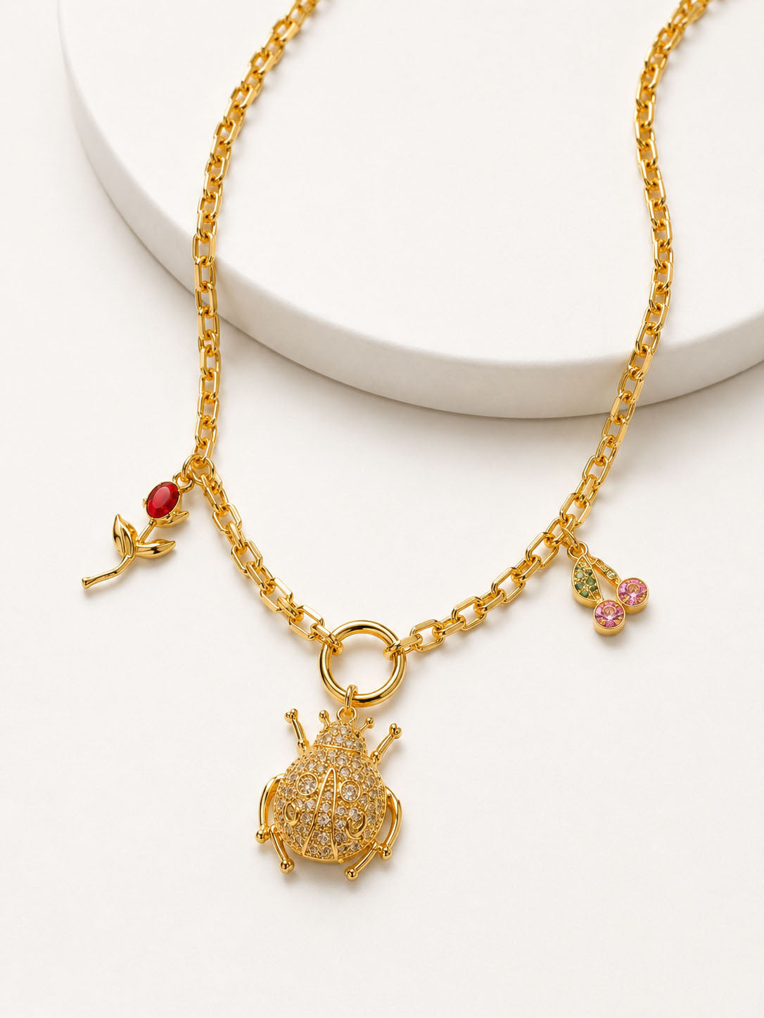 Gold necklace with a detailed pendant on a white background
