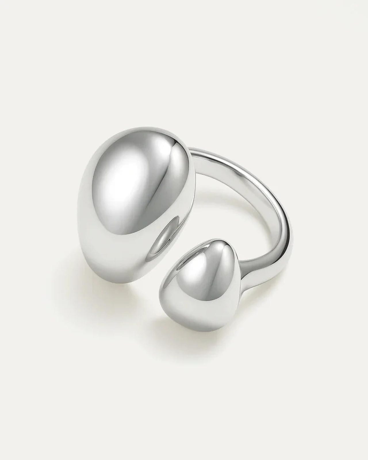 Silver ring with two rounded elements on a light gray background