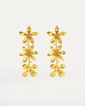 Gold-plated cascading flower drop earrings featuring three dimensional daisy designs stacked vertically, measuring 79mm in length with delicate petal details