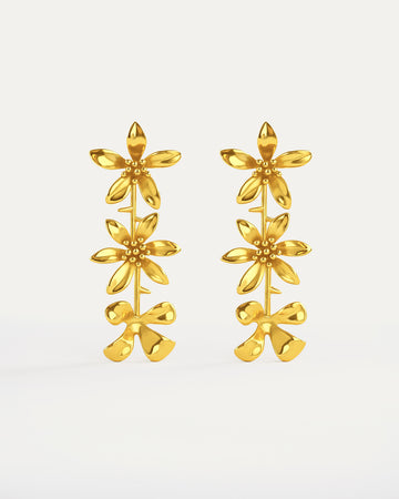 Gold-plated cascading flower drop earrings featuring three dimensional daisy designs stacked vertically, measuring 79mm in length with delicate petal details