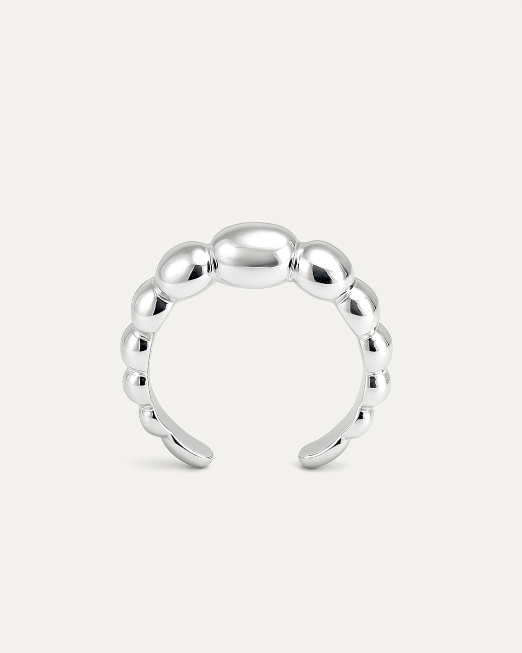 A close-up studio shot of a silver-tone cuff ring on a plain white or light beige background. The ring has an adjustable, ope