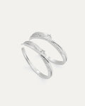 Two silver rings with small diamonds on a light gray background