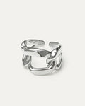 A close-up studio shot of a chunky, adjustable silver-tone ring on a plain white or light beige background.  