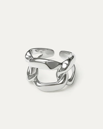 A close-up studio shot of a chunky, adjustable silver-tone ring on a plain white or light beige background.  