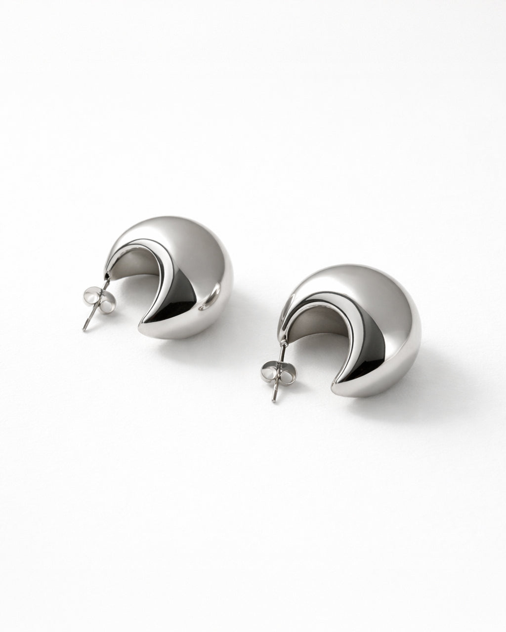 Jadejuri silver-plated dome hoop earrings, modern crescent studs on white bg