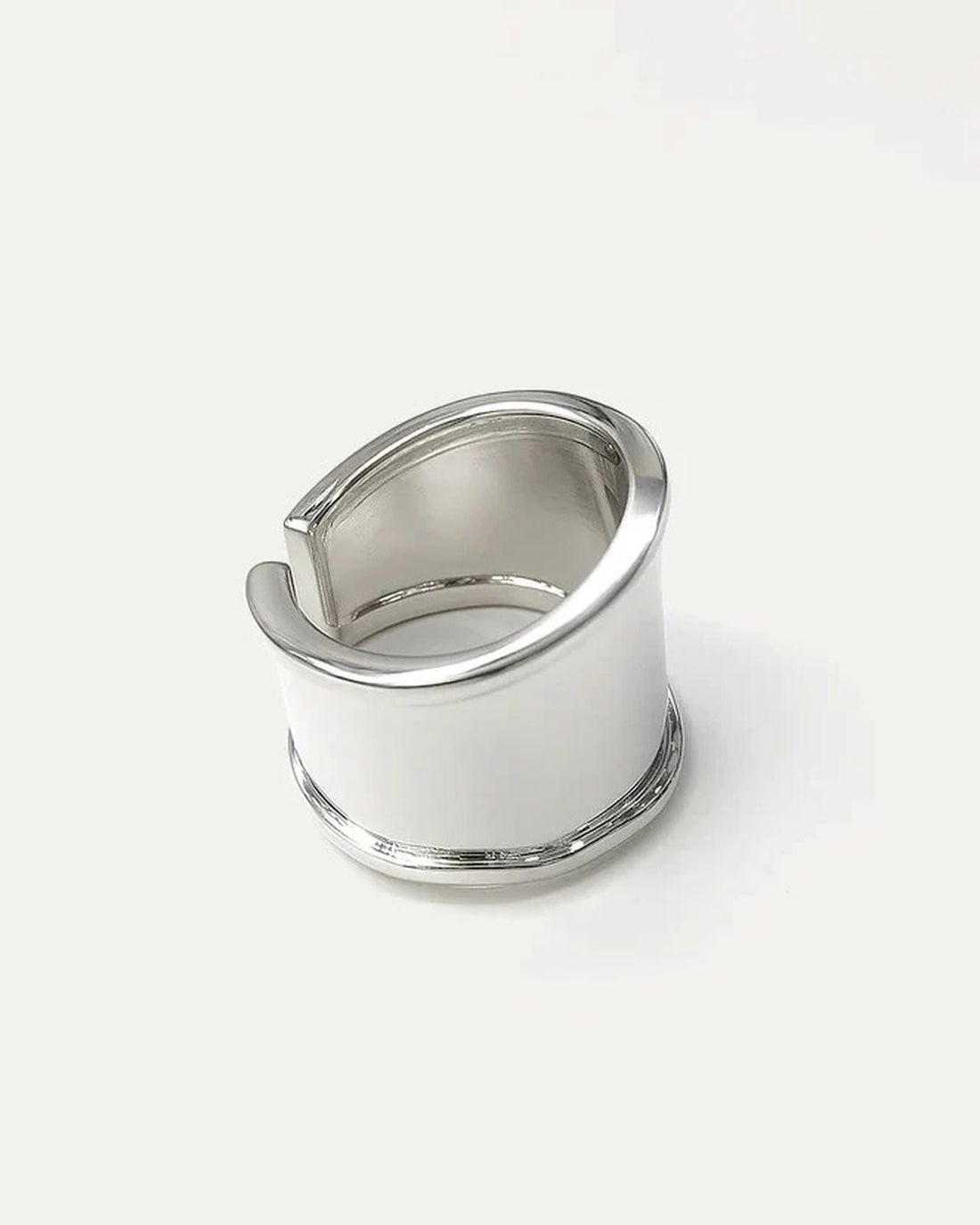 silver-plated wide band statement ring with curved top and open back design on white background