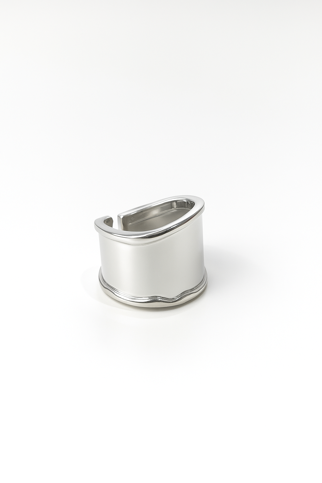silver-plated wide band statement ring with curved top and open back design on white background