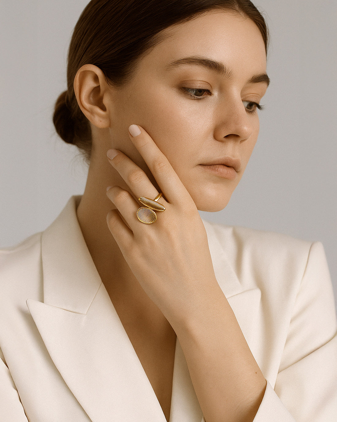 Asymmetrical gold ring with ribbed oval and capsule-shaped open ends