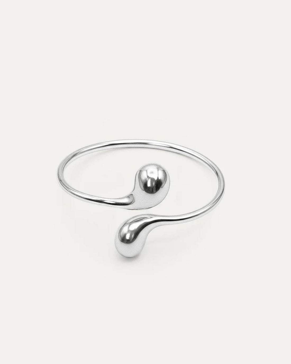 Eclipse Drop Cuff in silver-plated brass with double droplet ends and a polished sculptural finish