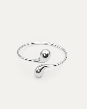 Eclipse Drop Cuff in silver-plated brass with double droplet ends and a polished sculptural finish