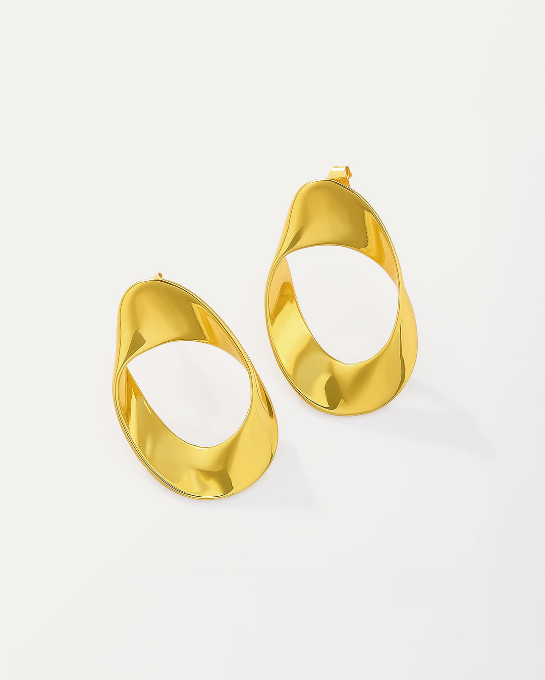 Modern asymmetric gold-plated hoop earrings with twisted oval design and hollow center, featuring a high-polish finish and contemporary sculptural shape