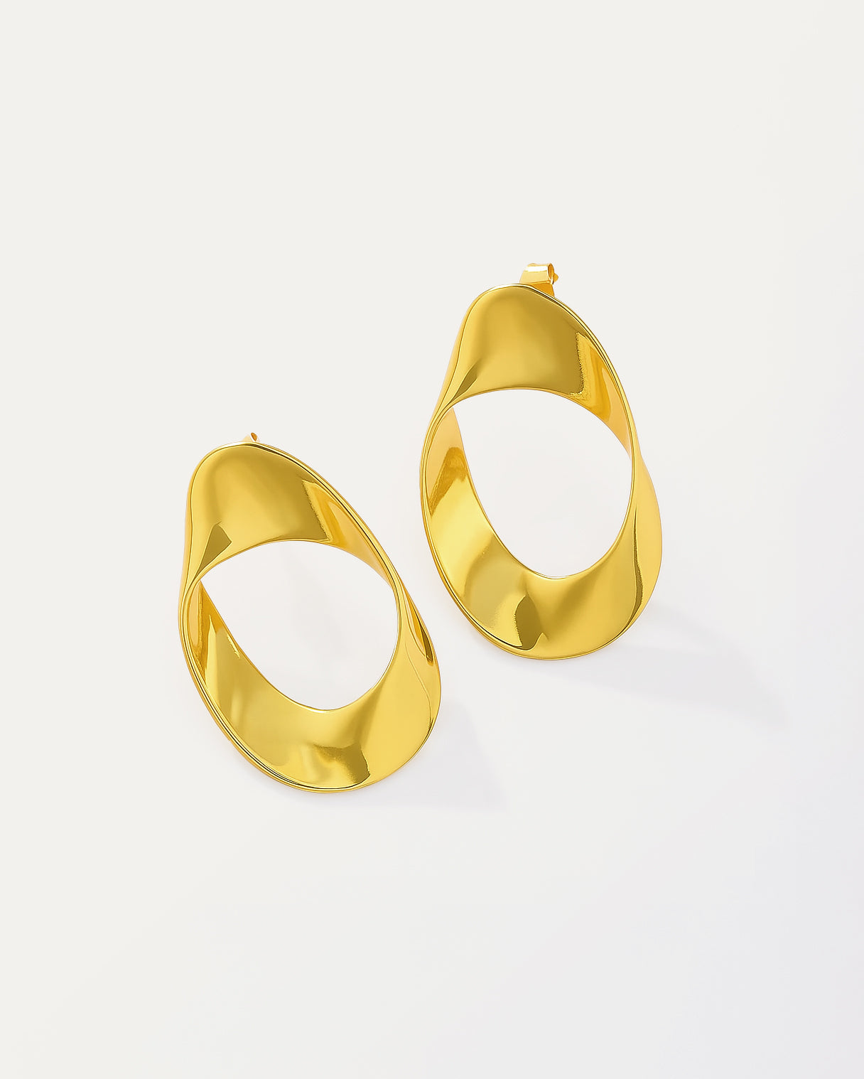 Modern asymmetric gold-plated hoop earrings with twisted oval design and hollow center, featuring a high-polish finish and contemporary sculptural shape