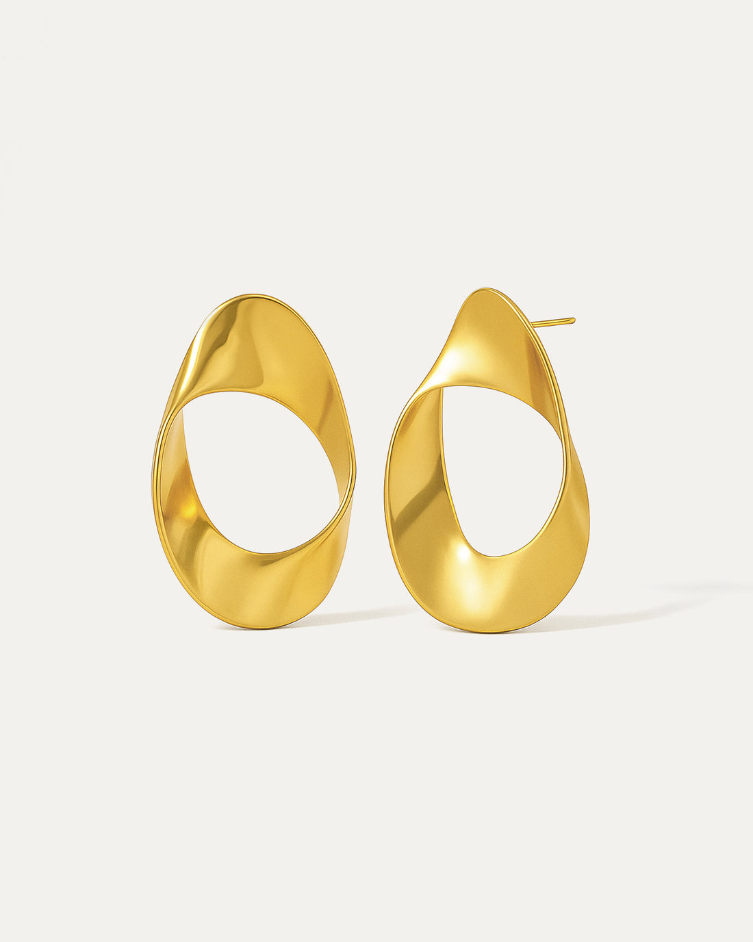 Modern asymmetric gold-plated hoop earrings with twisted oval design and hollow center, featuring a high-polish finish and contemporary sculptural shape