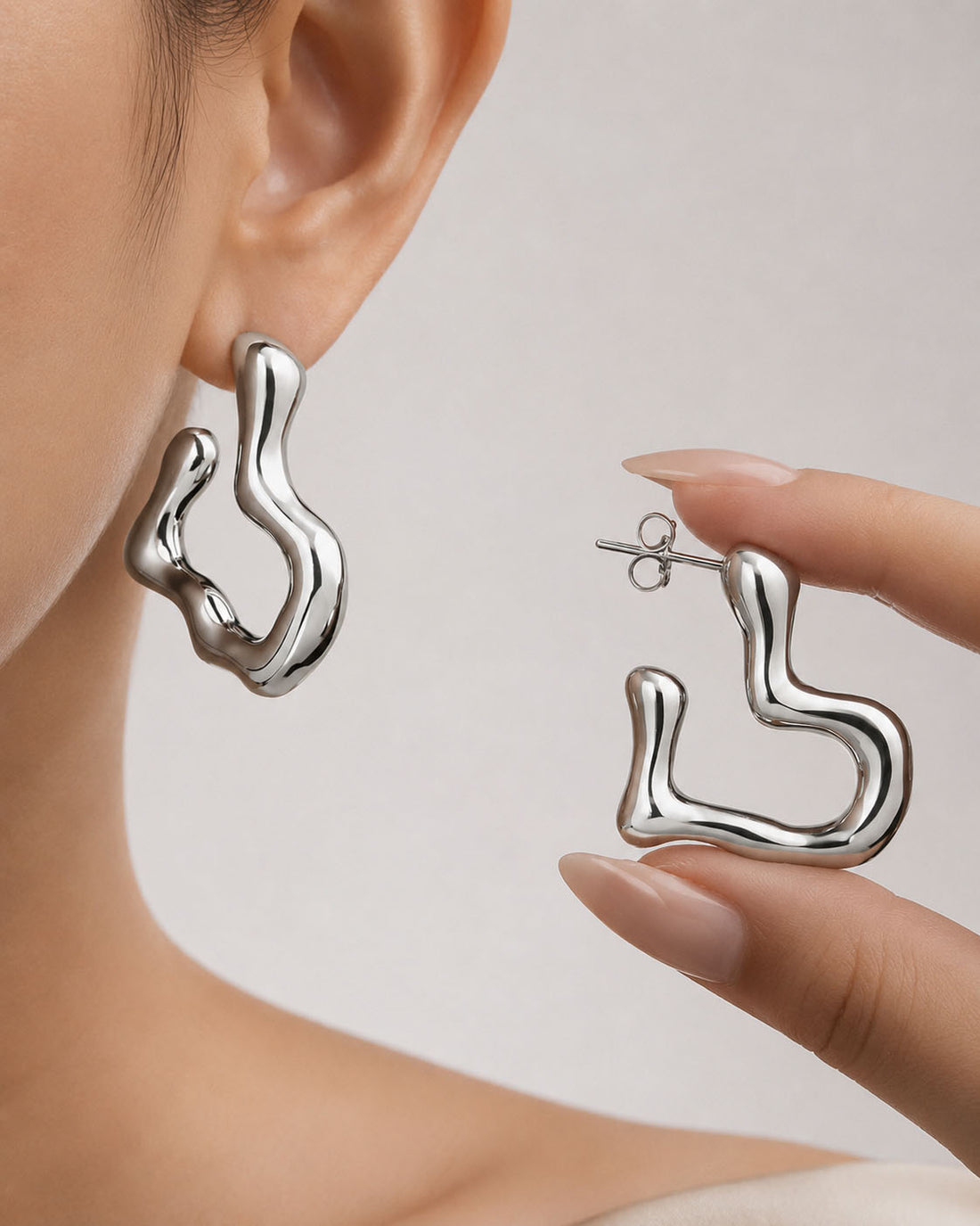 Silver hoop earrings on a light gray background