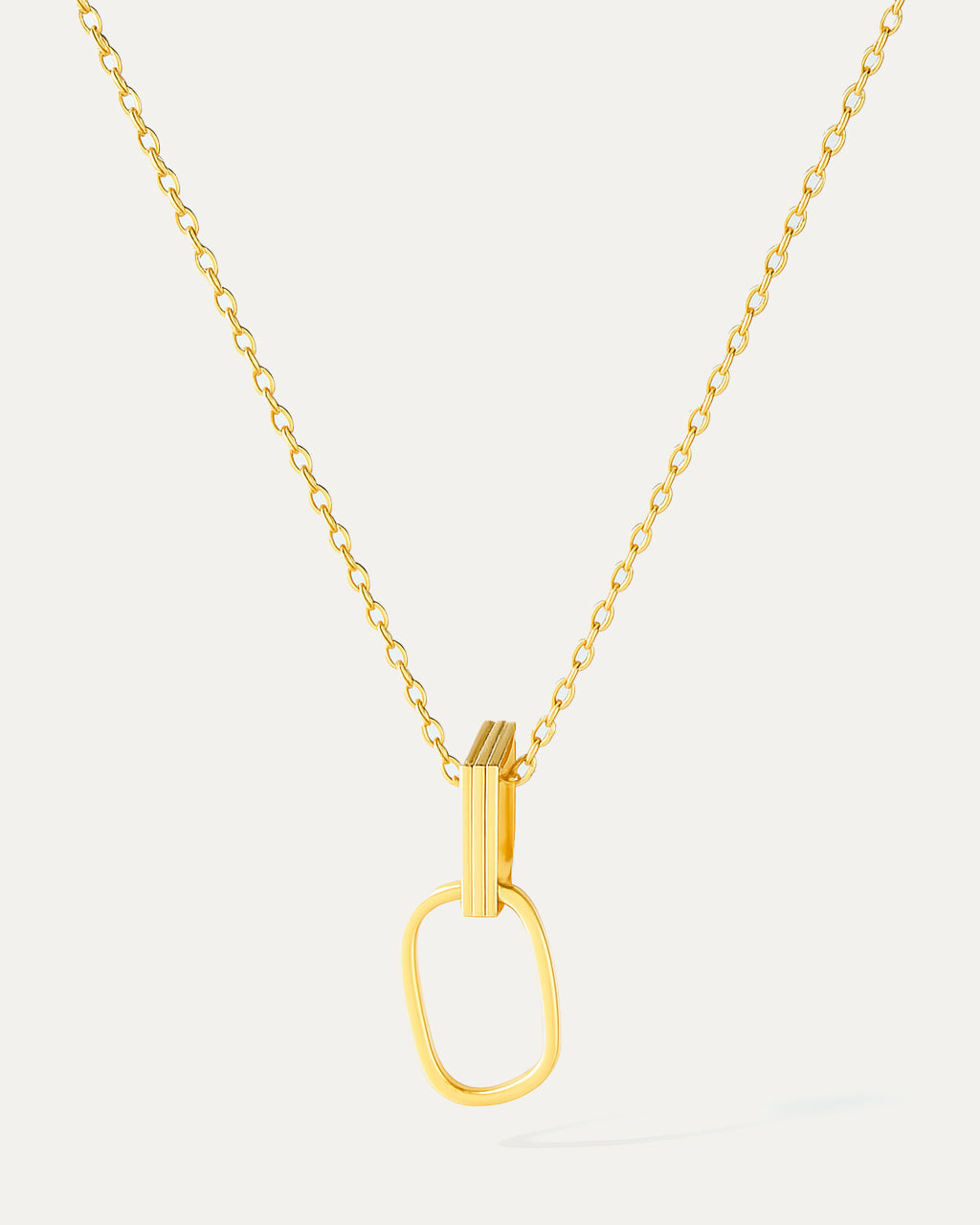 Gold necklace with a unique pendant on a light gray background