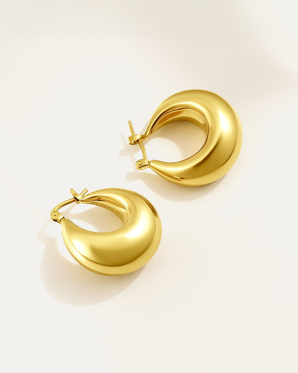 Gold hoop earrings on a light gray background