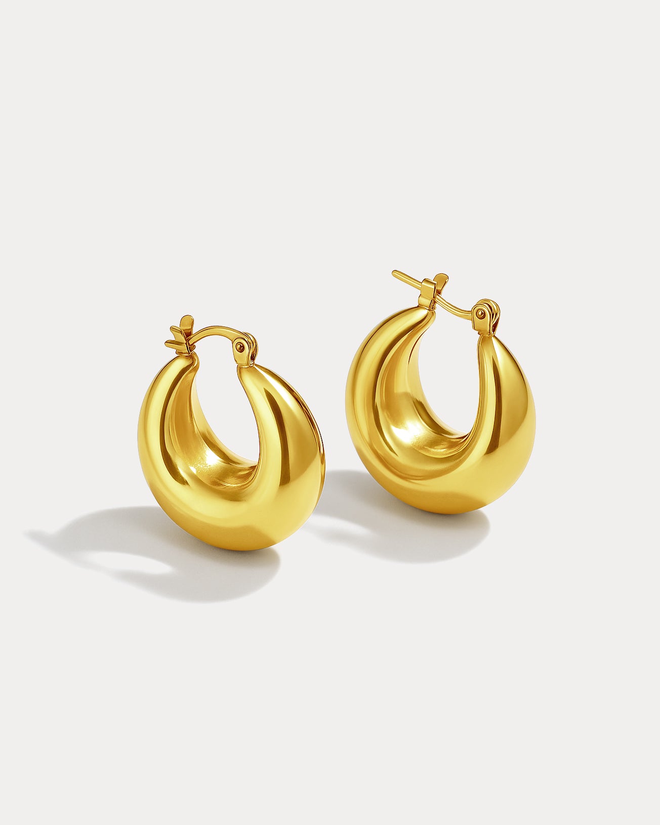 Gold hoop earrings on a light gray background