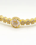 Gold bangle bracelet with floral centerpiece and sparkling crystals – Golden Bloom Radiance Bangle.
