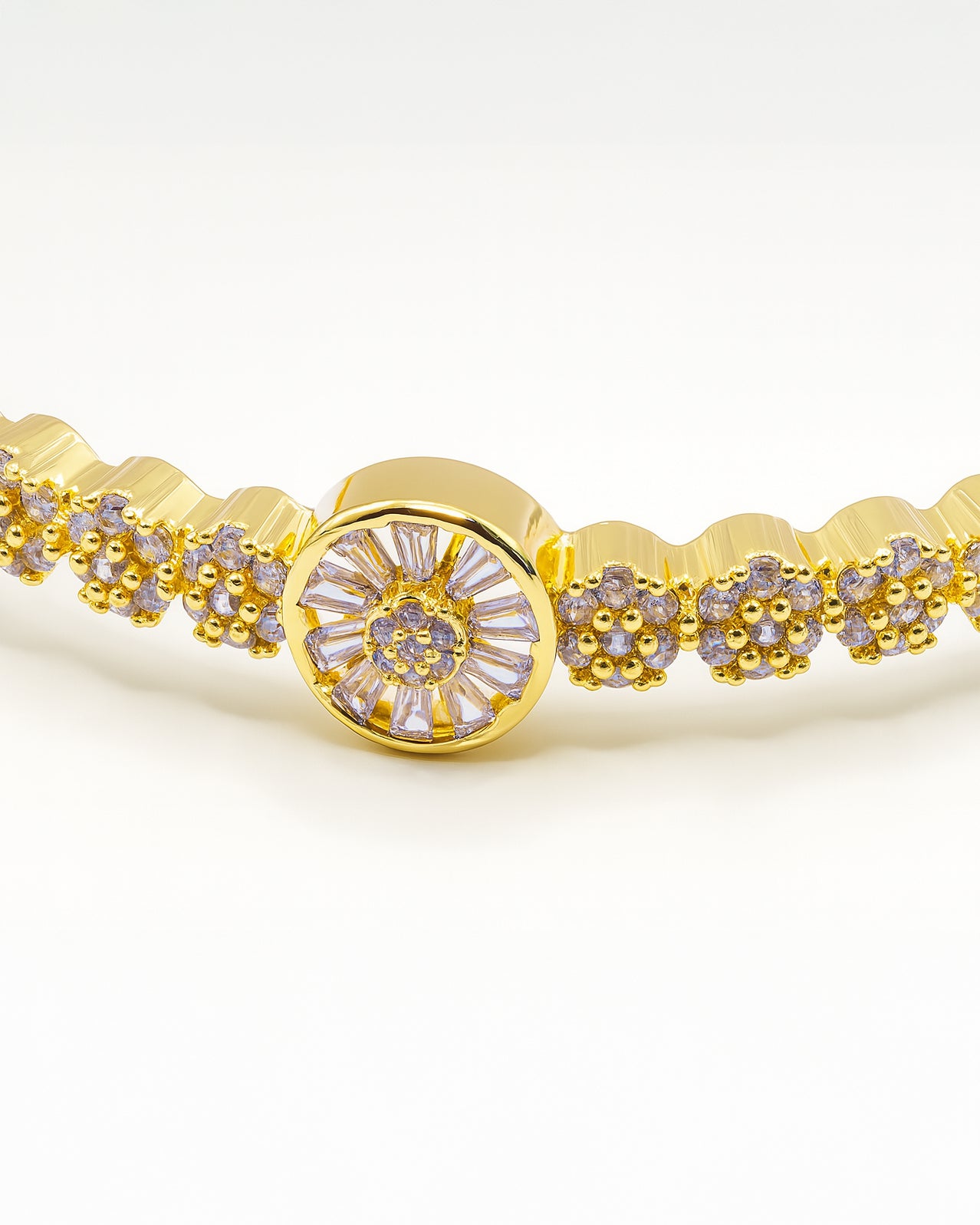 Gold bangle bracelet with floral centerpiece and sparkling crystals – Golden Bloom Radiance Bangle.
