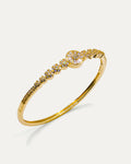 Gold bangle bracelet with floral centerpiece and sparkling crystals – Golden Bloom Radiance Bangle.