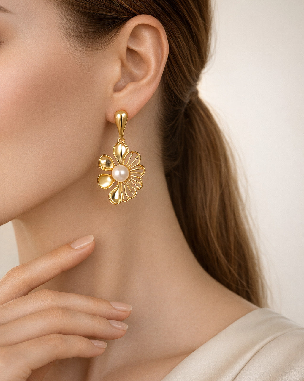 Intricate gold floral dangle earrings with a delicate chain. Perfect for adding a touch of elegance to any outfit.