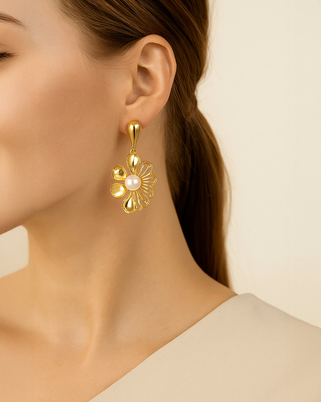 Intricate gold floral dangle earrings with a delicate chain. Perfect for adding a touch of elegance to any outfit.