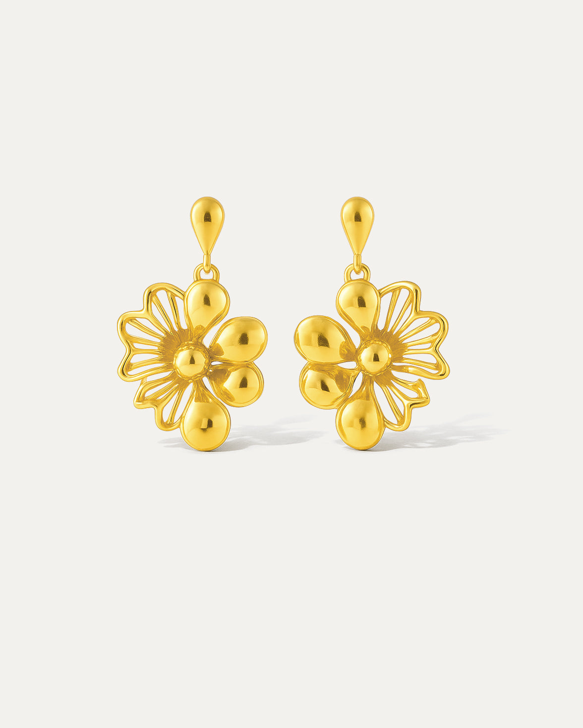 Intricate gold floral dangle earrings with a delicate chain. Perfect for adding a touch of elegance to any outfit.