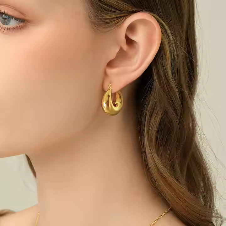 Gold hoop earrings on a light gray background
