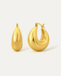 Gold hoop earrings on a light gray background
