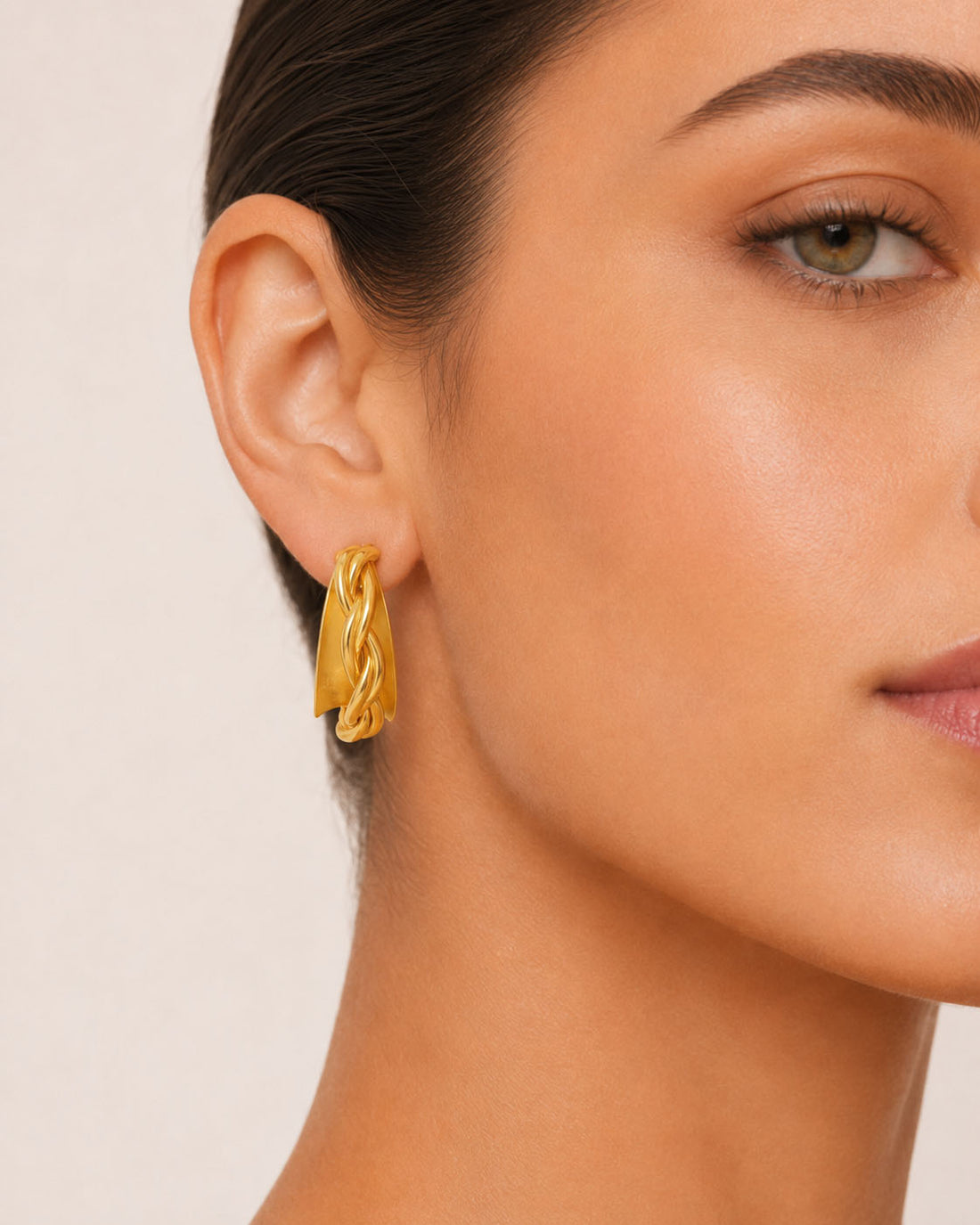 Pair of gold hoop earrings on a light gray background