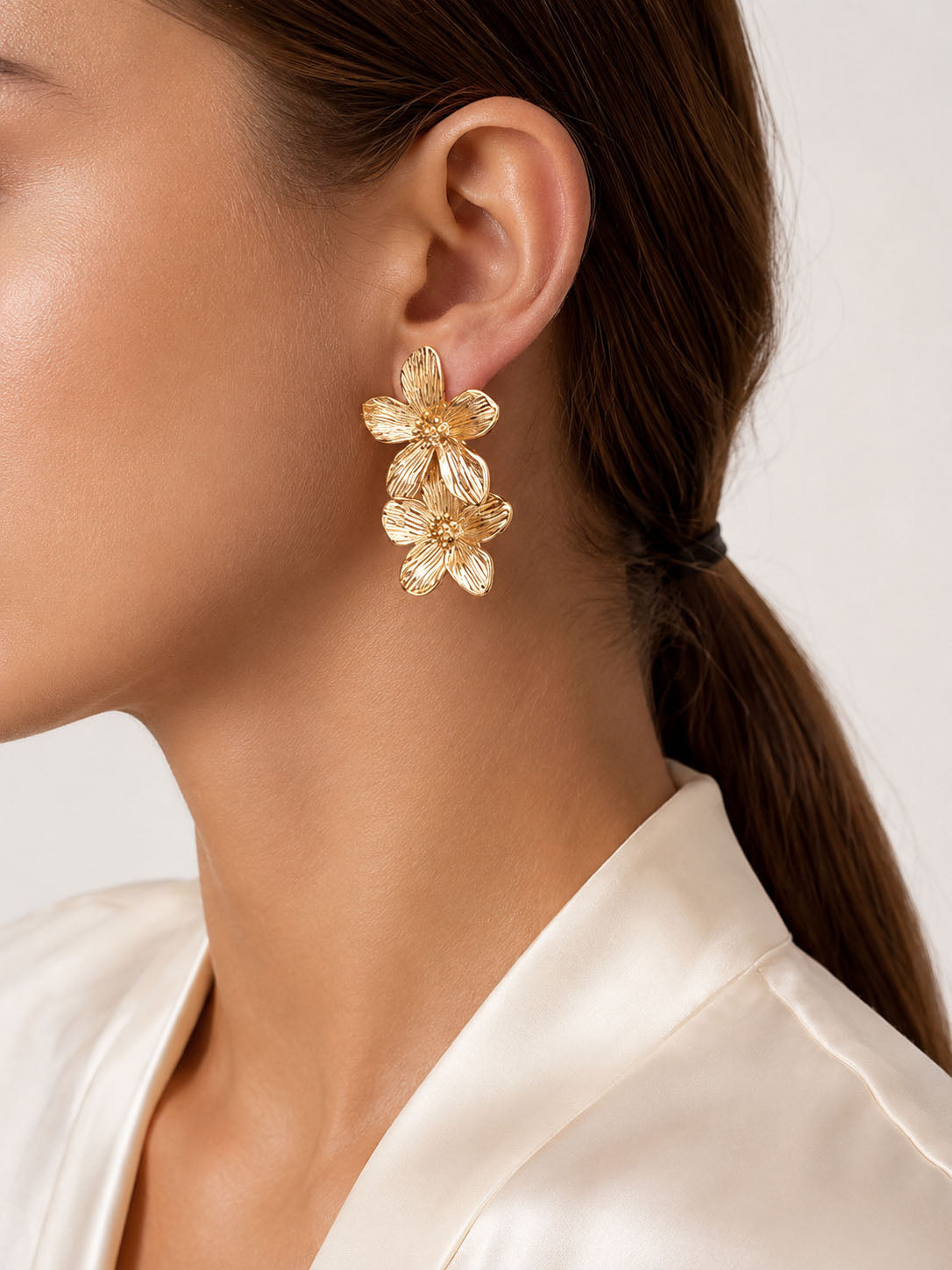Gold floral stud earrings with double flower design and polished 18K gold-plated finish