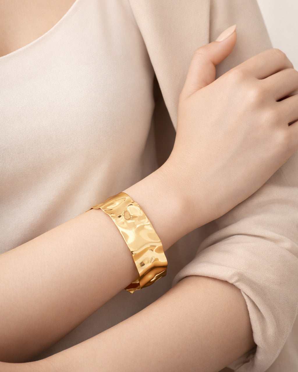 Wide hammered gold cuff bracelet on wrist, minimalist 18K gold plated jewelry