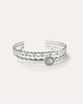 Silver-plated brass cuff bracelet with honeycomb cutouts and oval crystal accent on white background
