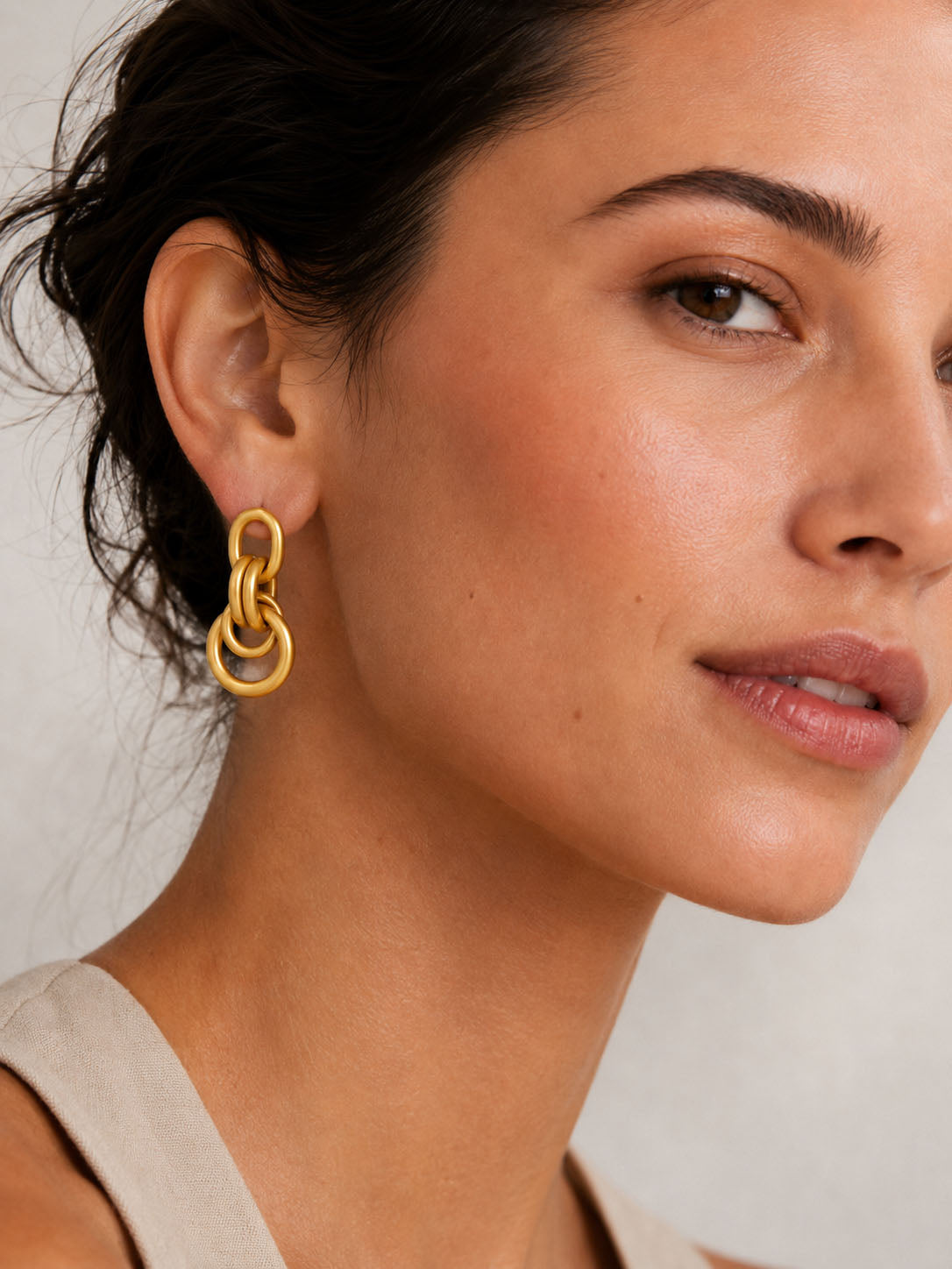 Gold chain-style earrings on a white background