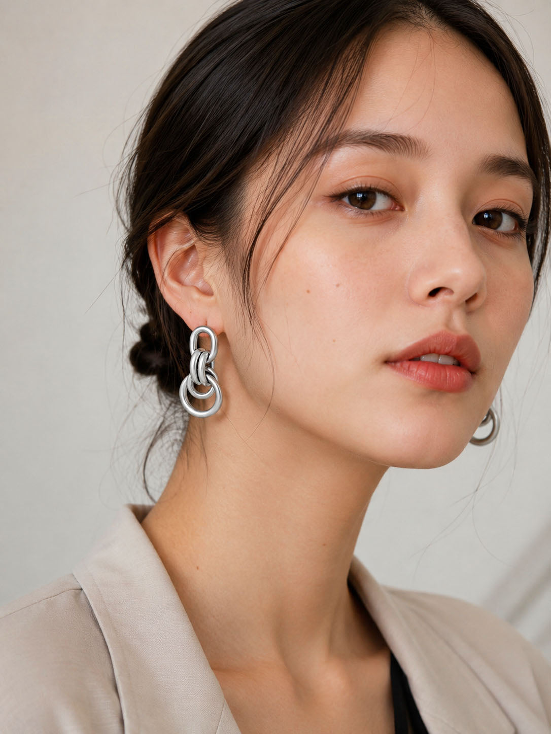 Silver-plated interlinked drop earrings on model, modern minimalist jewelry