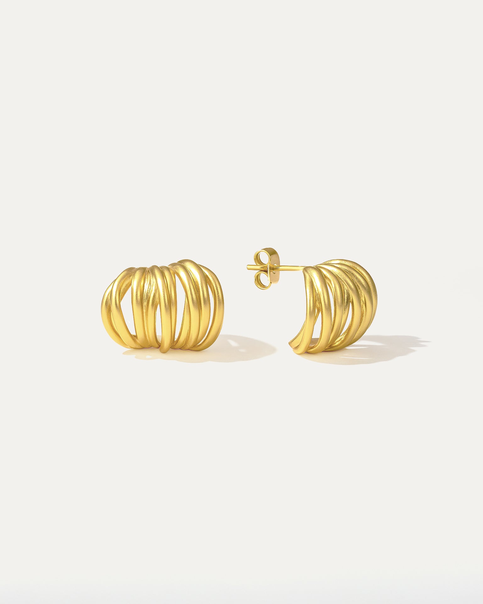 Gold hoop earrings on a light gray background