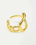 Gold ring with a twisted design on a light gray background