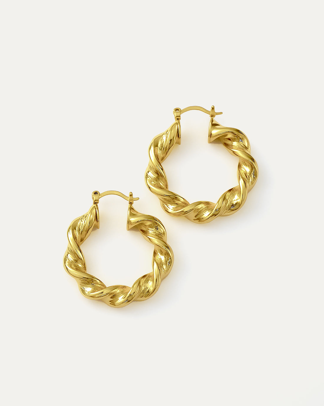 Gold hoop earrings on a light beige background