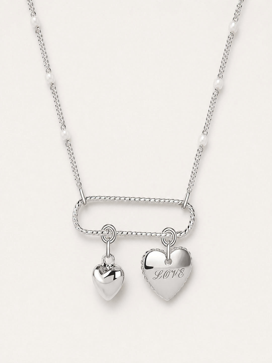 Silver necklace with heart-shaped pendants on a white background