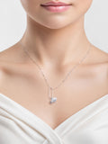 Silver necklace with a heart pendant worn by a model on a light background
