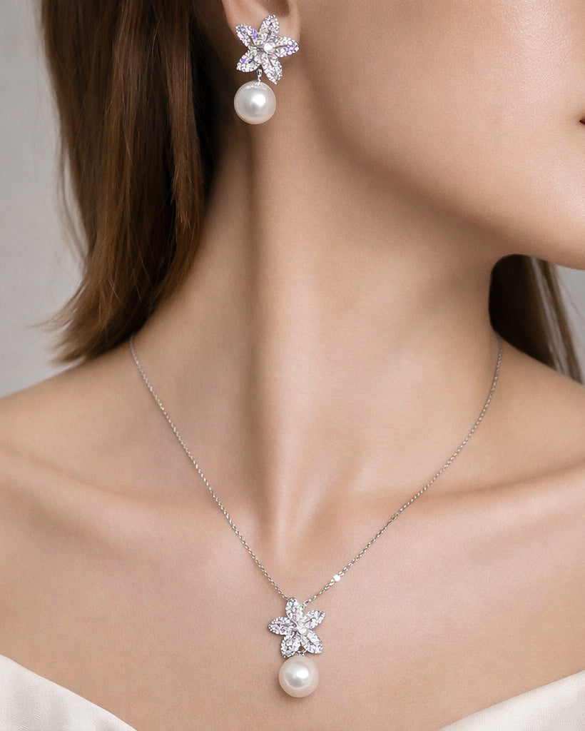 Pearl drop flower earrings and matching necklace in gold plated finish, worn on model