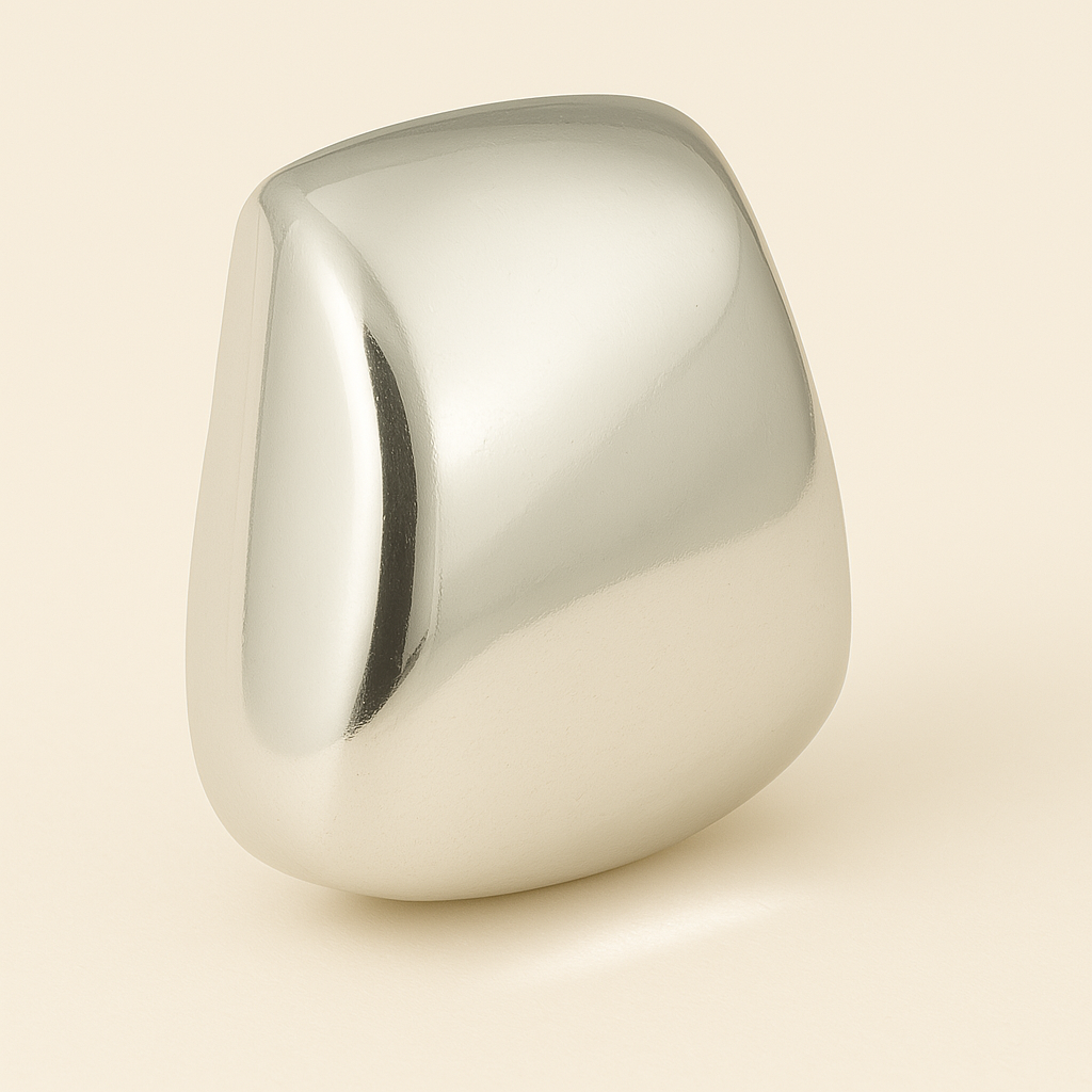 Polished silver dome ring with a melted, organic shape on a light beige background – minimalist sculptural jewelry.