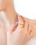Gold statement ring with fluid melted design and open-front structure